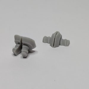 Two gray 3D printed multiboard multipoint screws with ridged bases and flat slotted tops