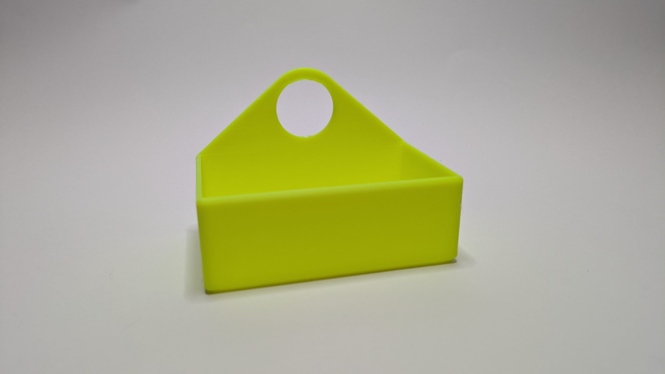 Tape Measure Holder1 Lime green 3D printed multiboard tape measure holder with circular handle opening and triangular profile
