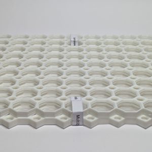 Stack of white multiboard tiles with pattern openings and branded tags