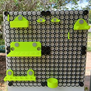 Neon yellow 3D printed multiboard tool holders mounted on black multiboard tiles